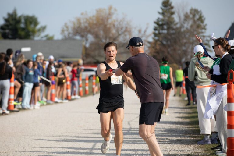 Fall 50 relay runner reaching for a hand-off at Exchange 1