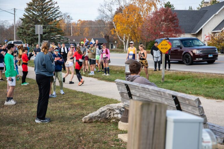 Costumed relay runners making a hand-off at Fall 50 Exchange 2 in Sister Bay