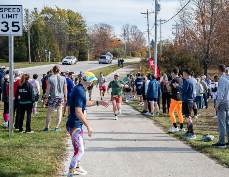 Runner arriving at Fall 50 Exchange 2 on the Sister Bay trail