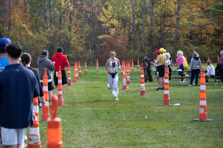 Runner finishing Leg 3 at Fall 50 Exchange 3, Nicolet Bay Beach