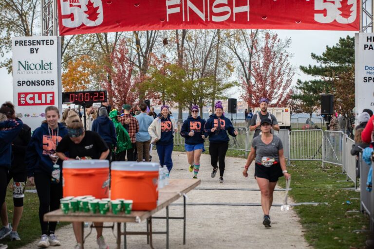 Runners crossing the Fall 50 finish line at Sunset Park in Sturgeon Bay