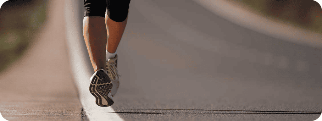 A runner’s feet on a paved road